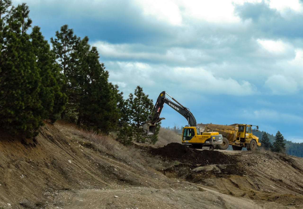 Crafting Captivating Headlines: Your awesome post title goes here Excavator and truck working at a construction site in Coeur d'Alene, Idaho with cloudy skies.